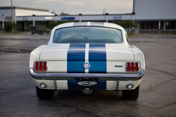 A back view of a 1966 Shelby GT 350/ GT350H parked on the road.