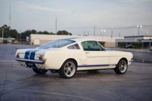 A side view of a 1966 Shelby GT 350/ GT 350H parked on a parking lot.