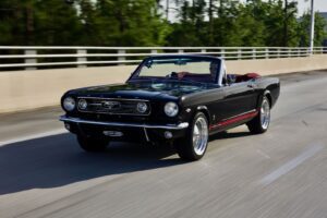 A black 1966 Mustang Convertible on a road.