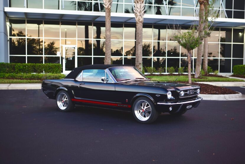 Wide shot of a black 1966 Mustang Convertible parked in front of a house.