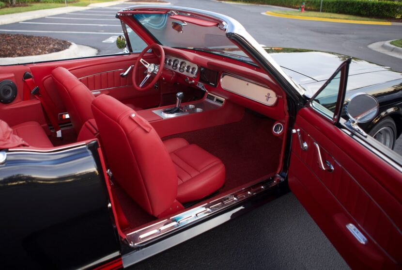 Red interior of a 1966 Mustang Convertible with a right door open.