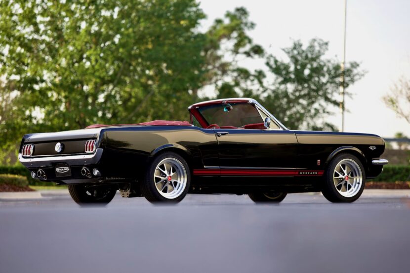 A lateral view of a black 1966 Mustang Convertible with red stripes.