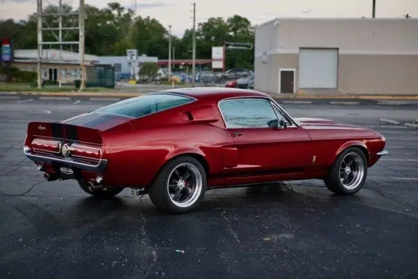 Back view of a red 1967 Shelby GT 350 on a parking lot.