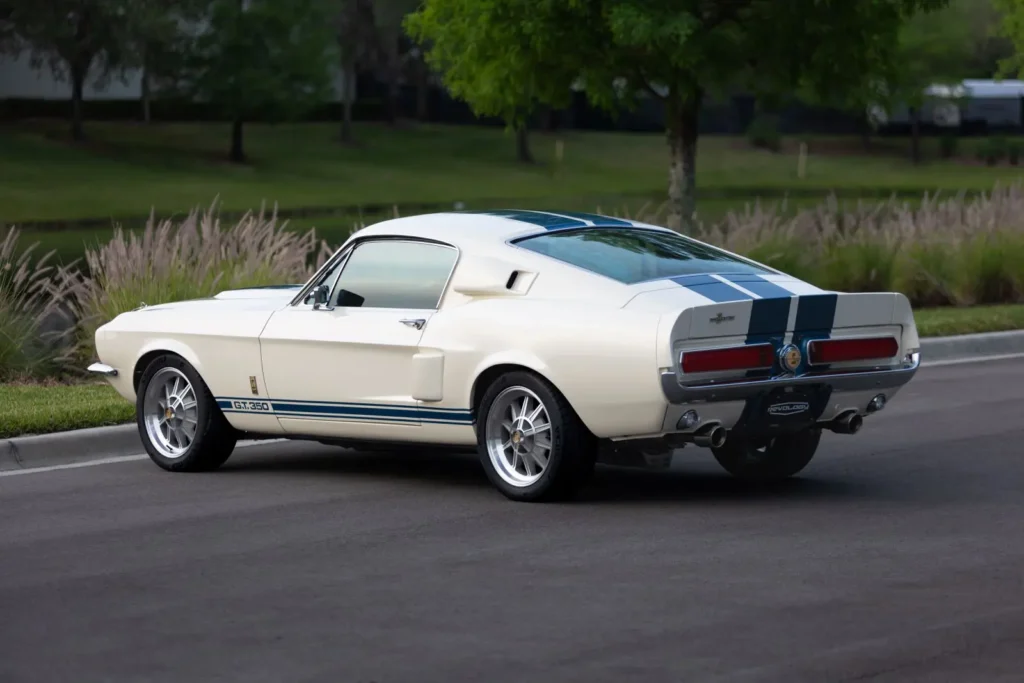 Back view of a white 1967 Shelby GT 350 on a parking lot.