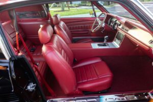 Red interior of a 1967 Mustang GT / GTA 2+2 Fastback with a right door open.
