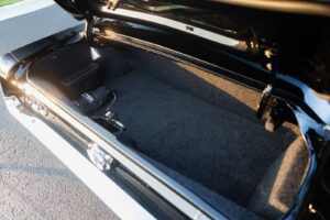A close-up of a black 1967 Mustang GT / GTA 2+2 Fastback open trunk.