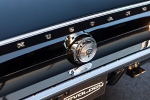 A close-up of a 1967 Mustang GT / GTA 2+2 Fastback trunk emblem.