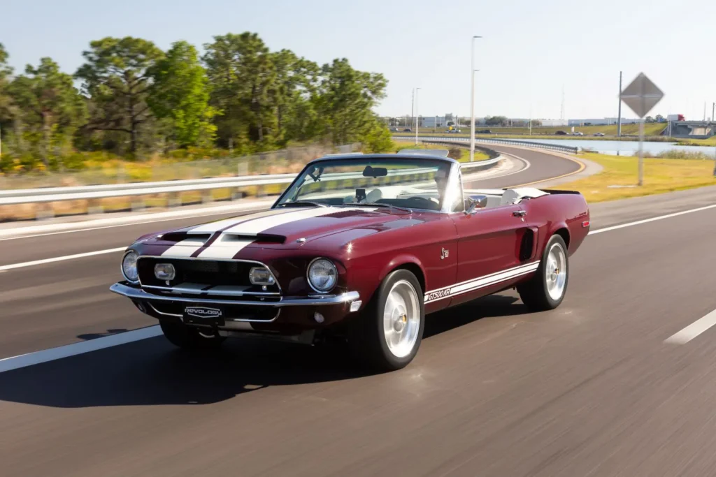 Driver driving 1968 Shelby GT500 KR Convertible in motion on road shot