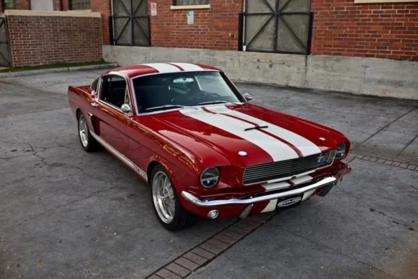 Red 1966 Shelby GT 350/ GT 350H side looks parked in a parking lot.