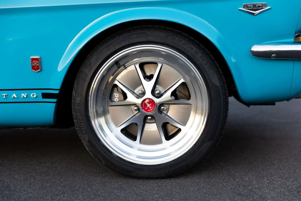 Back wheel rim on a blue 1966 Mustang Convertible tire.