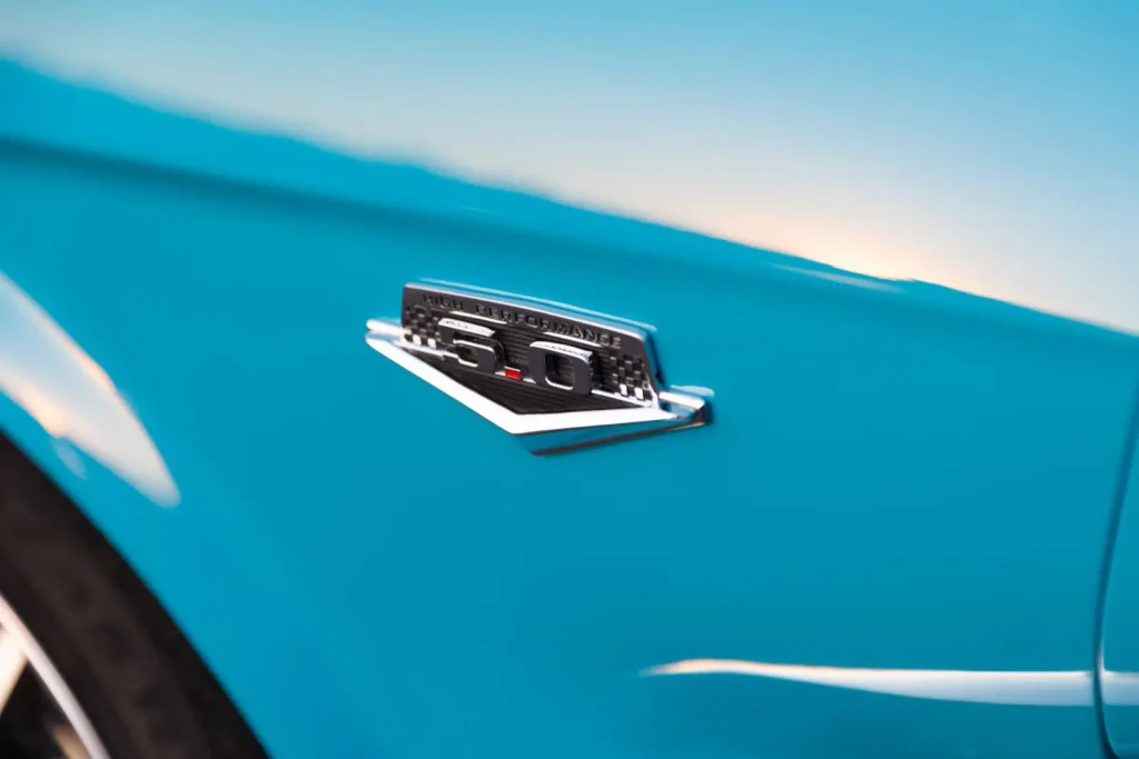 Close shot of a blue 1966 Mustang Convertible side emblem.