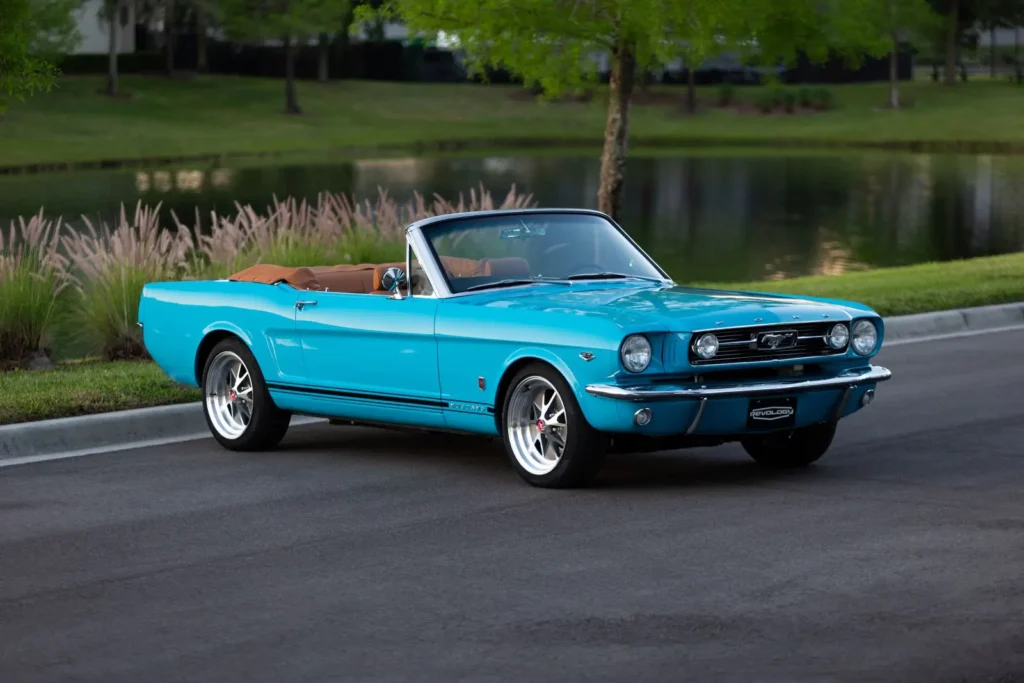 A lateral view of a blue 1966 Mustang Convertible parked with open roof.