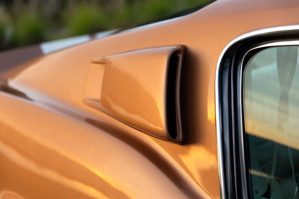 Close-up of the functional passenger-side quarter panel scoop on a Copper metallic 1967 Revology Shelby GT350 Fastback.