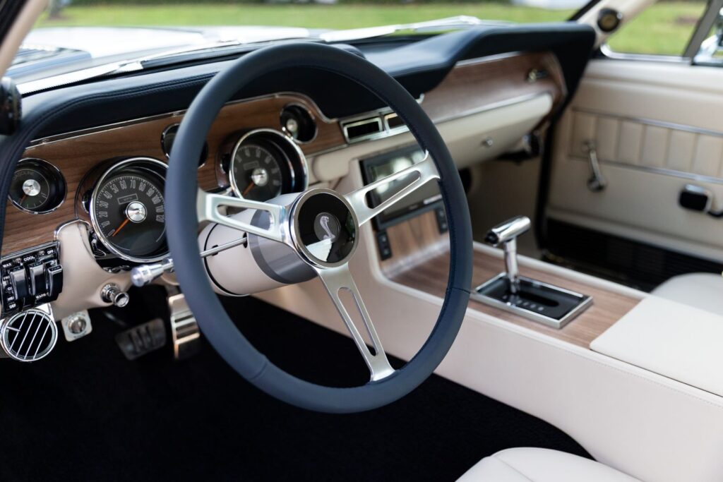 The perfect blend of heritage and technology: Revology's 1968 Shelby GT500KR interior pairs iconic wood grain accents with a modern automatic transmission for an effortless driving experience.