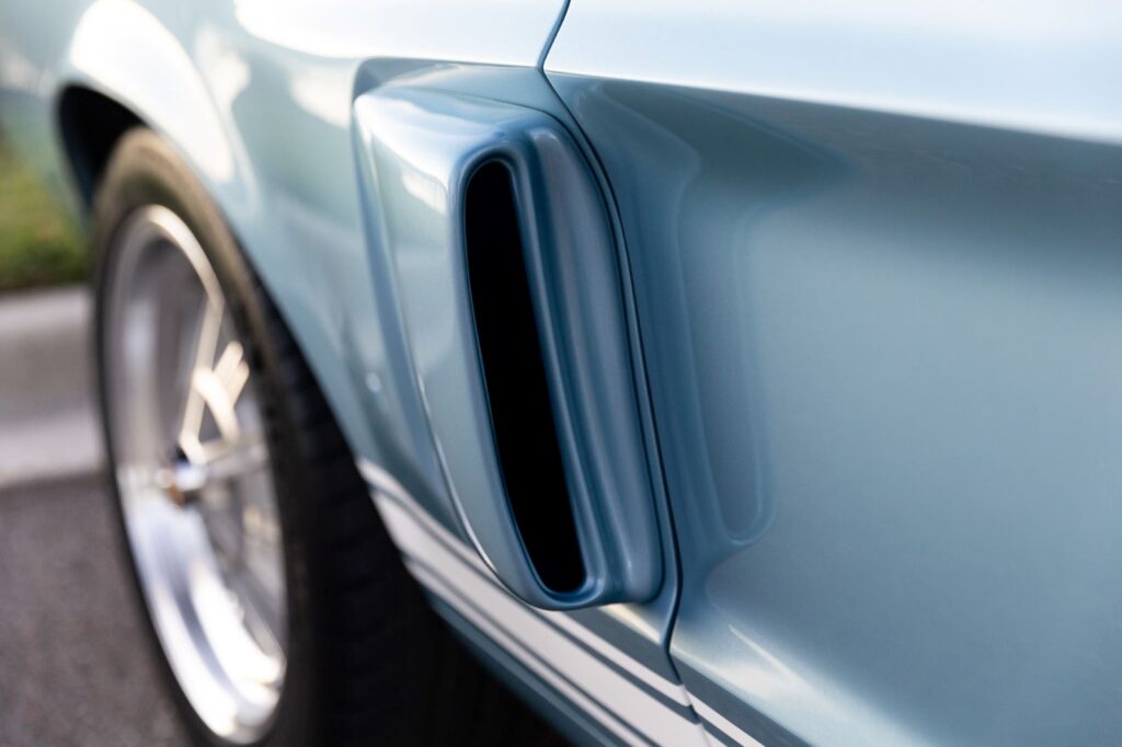 Close-up of the functional side scoop and rear quarter panel of a 1967 Revology Shelby GT500 Fastback in metallic blue.