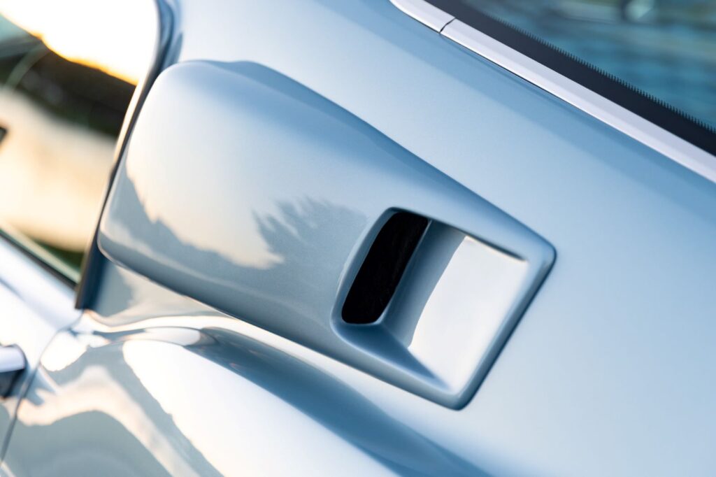Angled close-up of the functional B-pillar air extractor vent on the roof line of a metallic blue 1967 Revology Shelby GT500 Fastback.