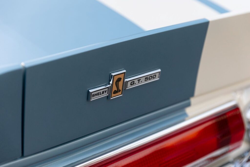 Close-up of the Shelby G.T. 500 Cobra badge on the rear trunk lid of a metallic blue 1967 Revology Fastback.