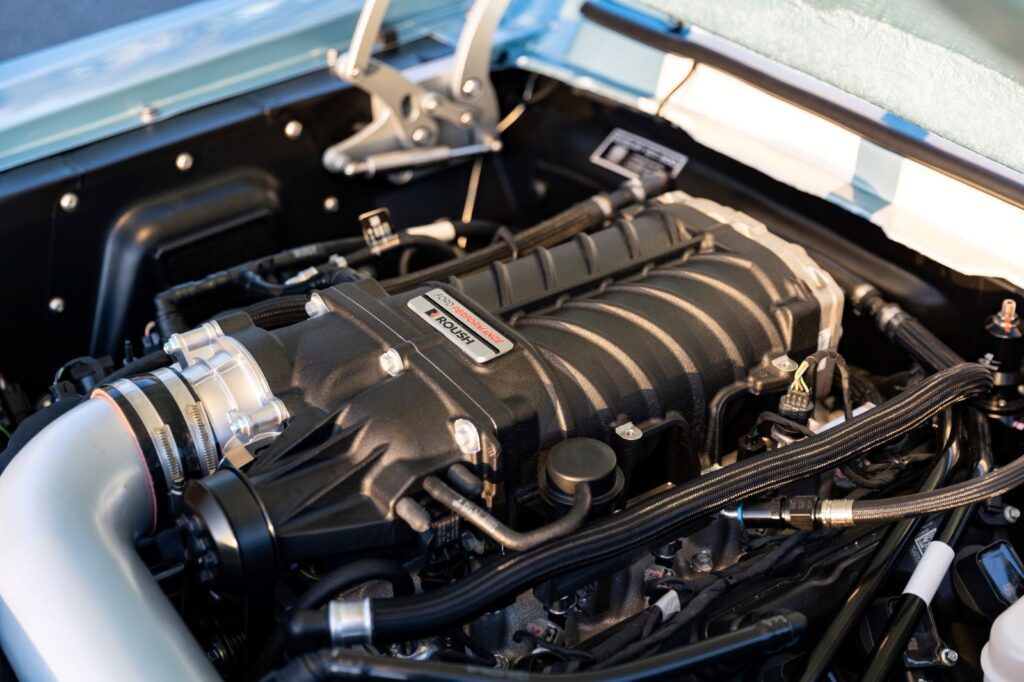 Close-up of a Roush supercharger mounted on a 5.0L Coyote V8 engine in a 1967 Revology Shelby GT500.