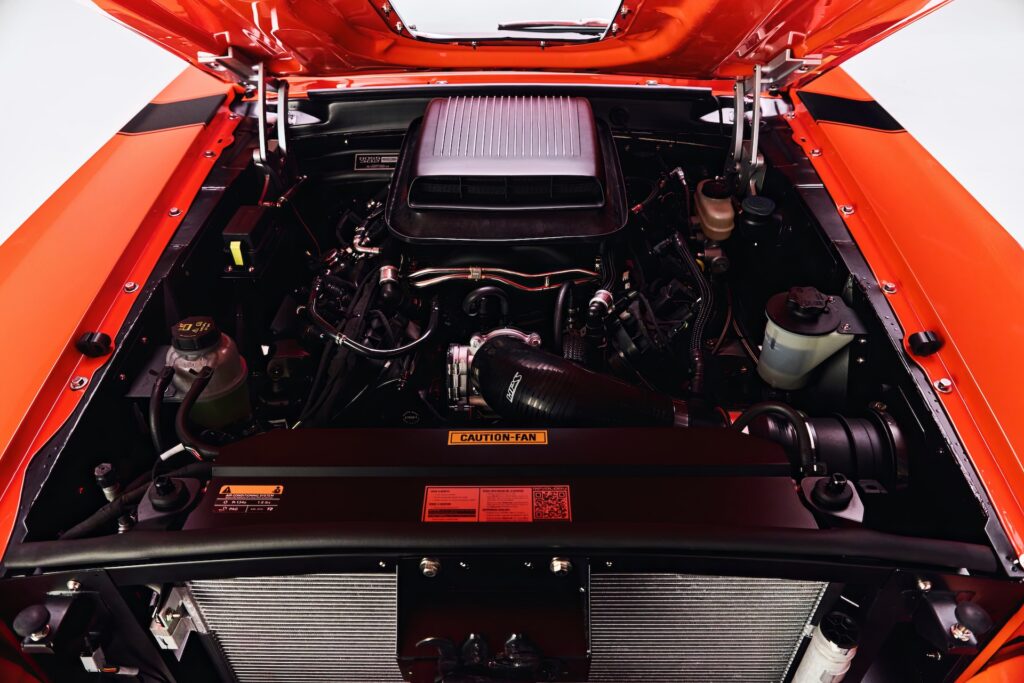 Engine bay of a Revology Cars classic Ford Mustang Boss 302 featuring a 460 HP Gen 4 5.0L Coyote V8 engine and a functional Shaker hood scoop.