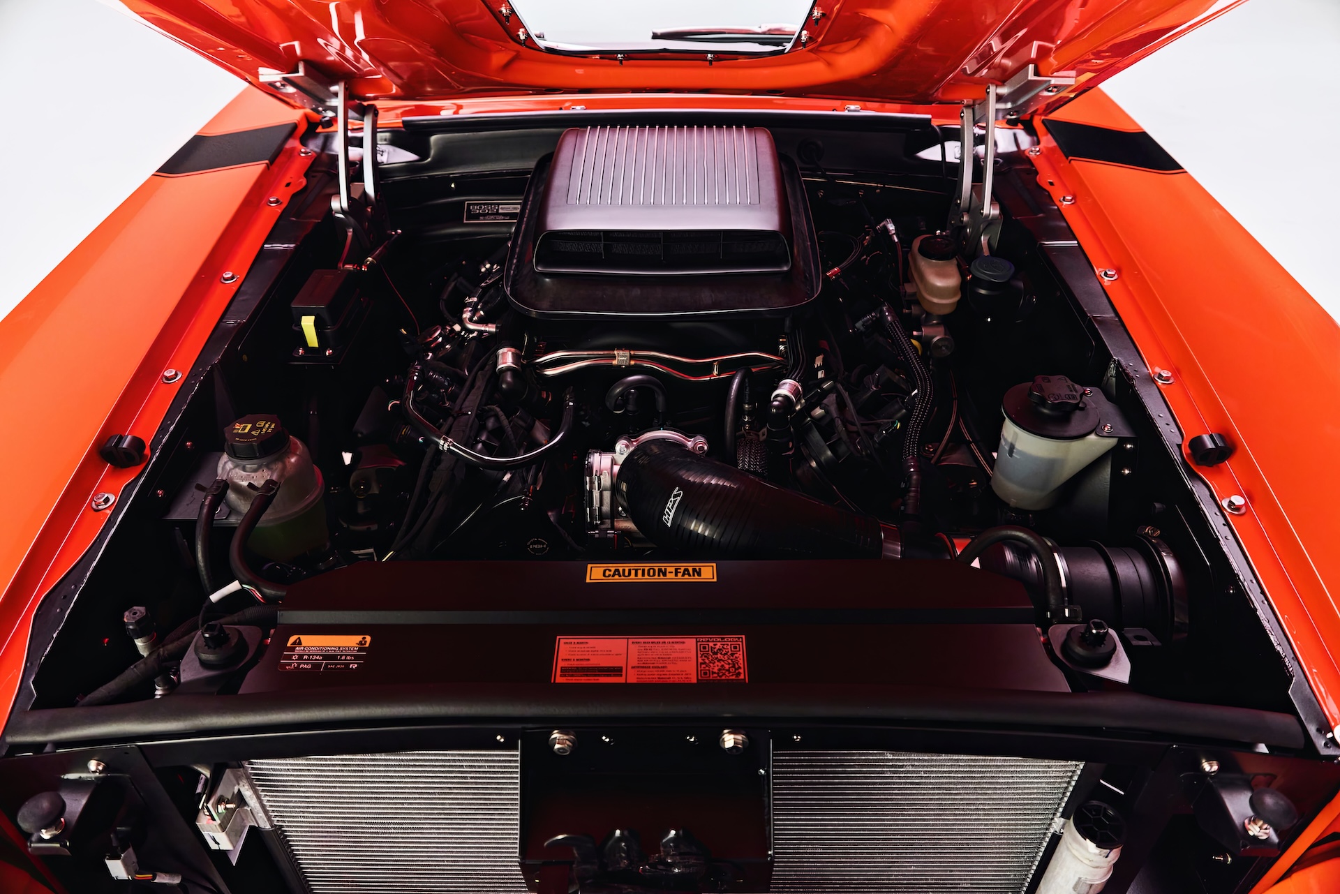 Engine bay of a Revology Cars classic Ford Mustang Boss 302 featuring a 460 HP Gen 4 5.0L Coyote V8 engine and a functional Shaker hood scoop.